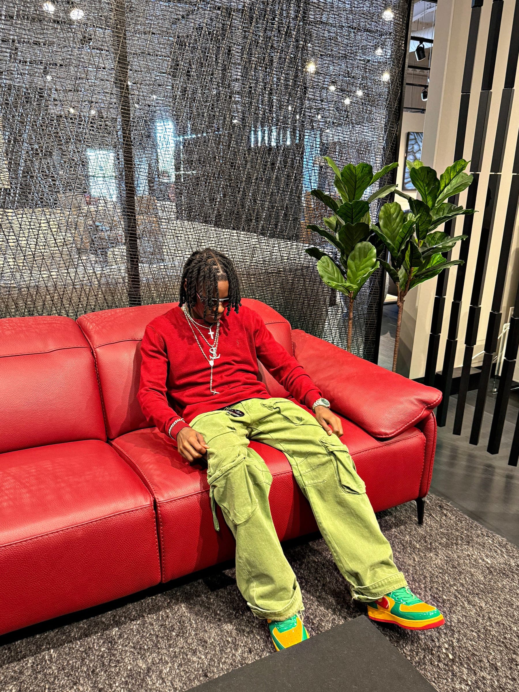 Strange Loots streetwear — lookbook shot on a red sofa