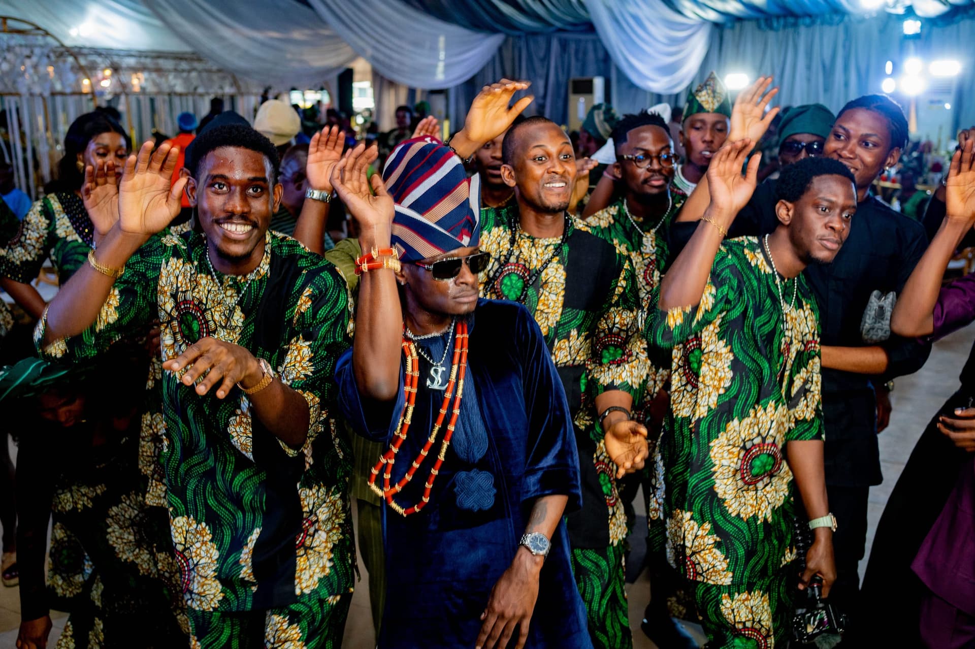 Family and friends dancing in matching ankara at a Lagos celebration